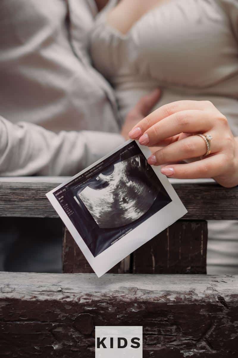 a woman holding a picture of a baby in her lap