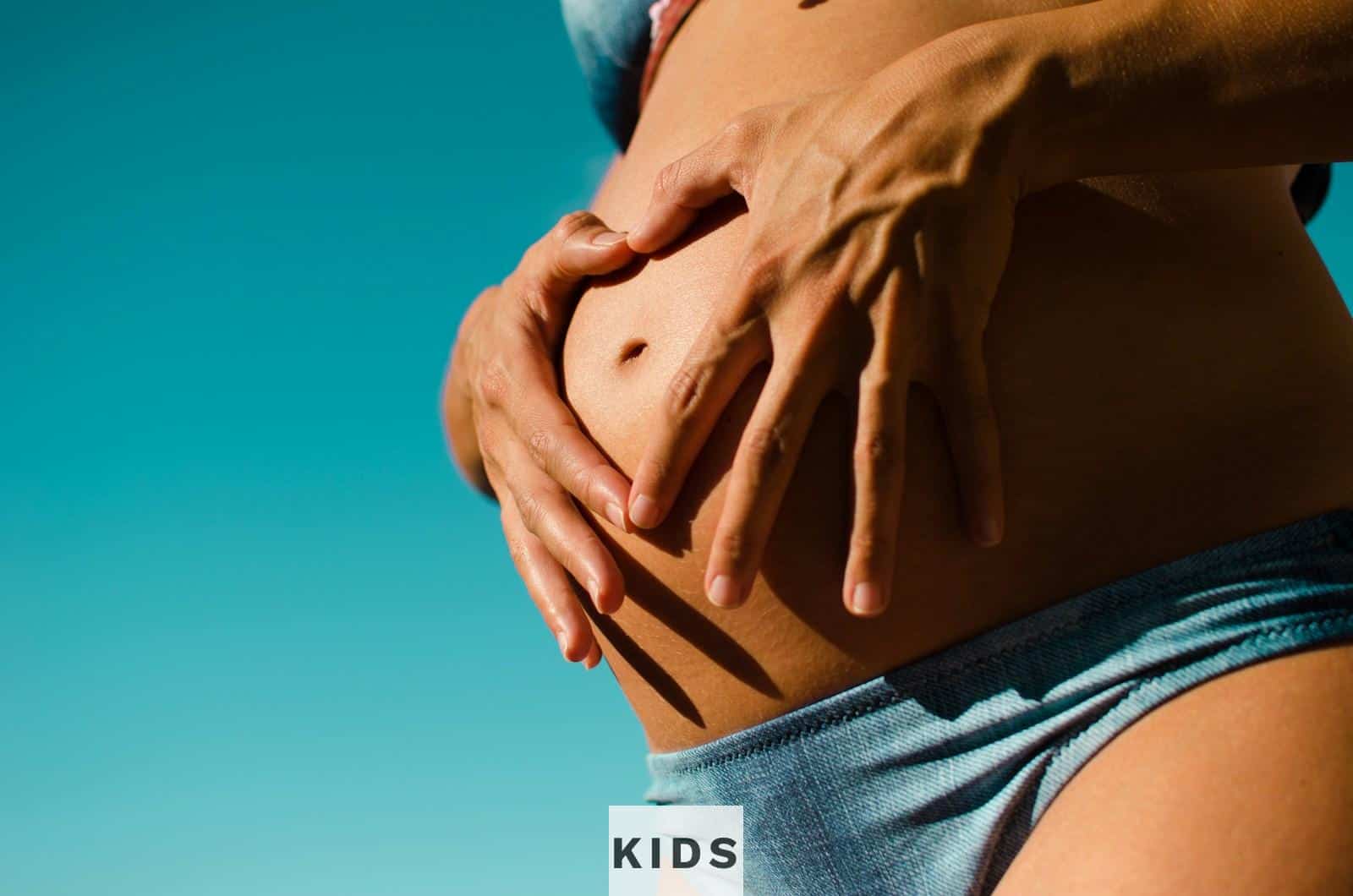 closeup photography of pregnant woman wearing blue panty