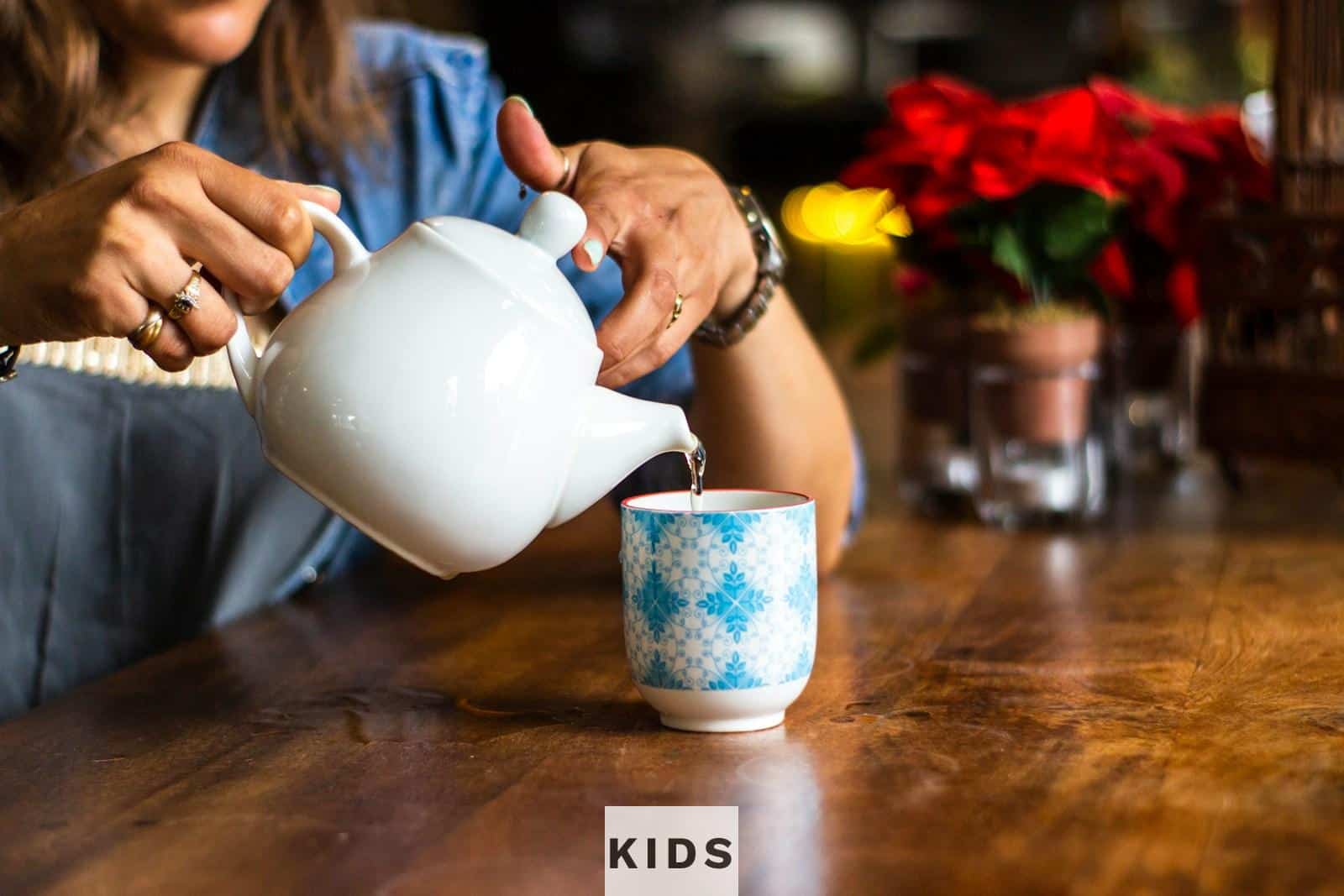 unknown person holding white ceramic kettle