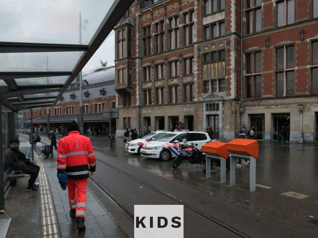 a man walking down a street next to tall buildings