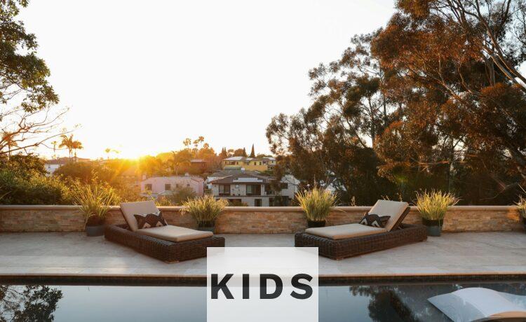 a pool with two lounge chairs and a view of a house