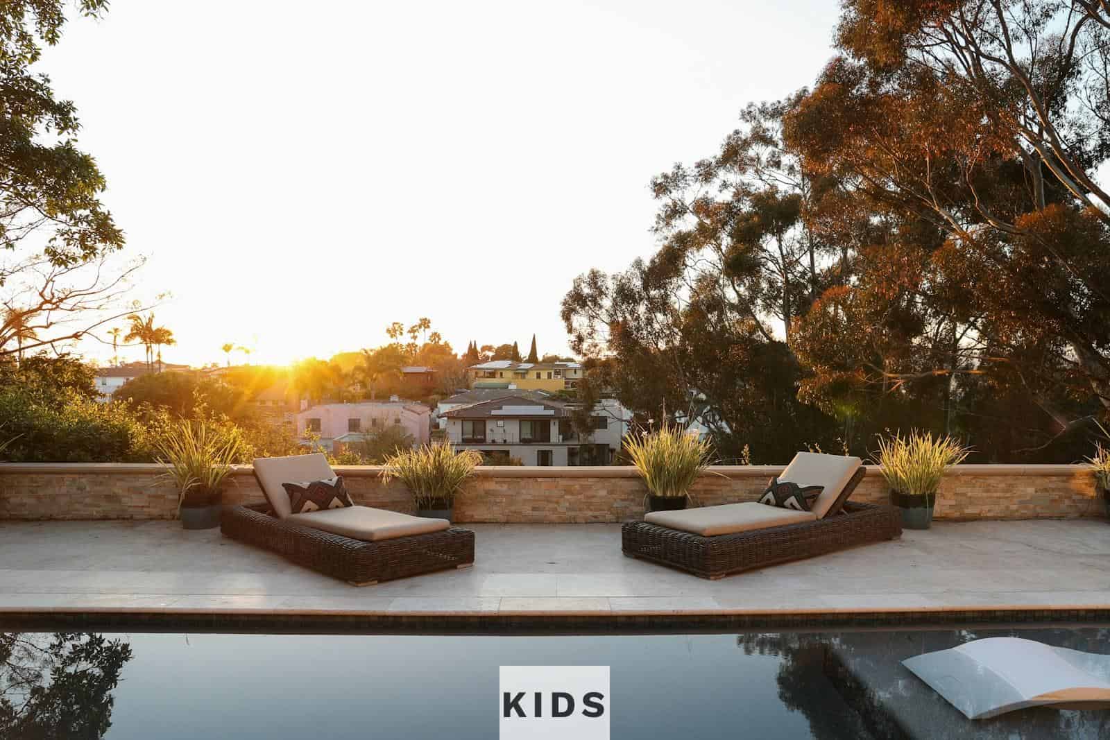 a pool with two lounge chairs and a view of a house