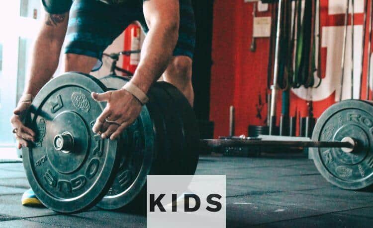 man placing weight plate on barbell