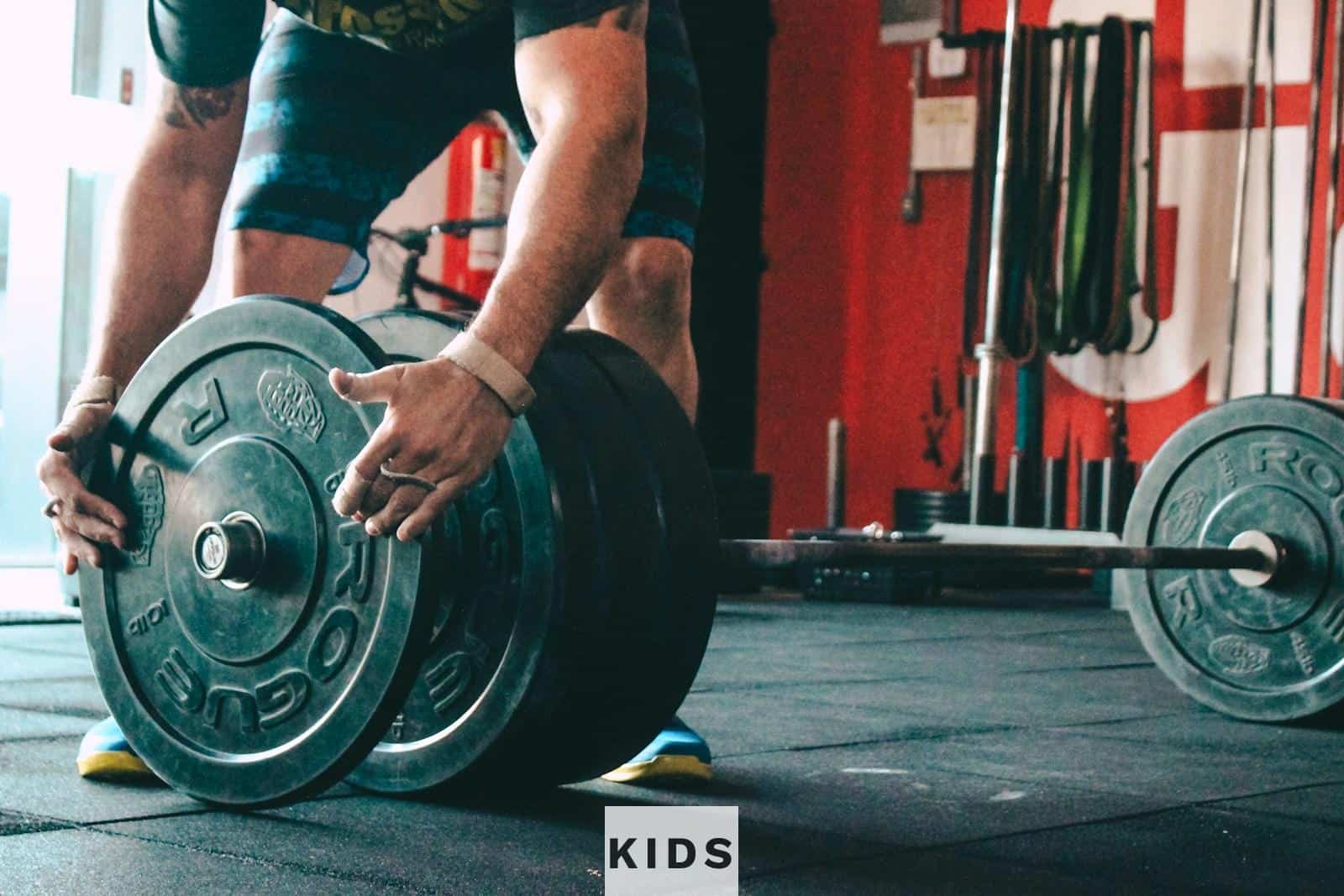 man placing weight plate on barbell