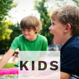 boy in blue shirt screaming near boy in green crew-neck shirt